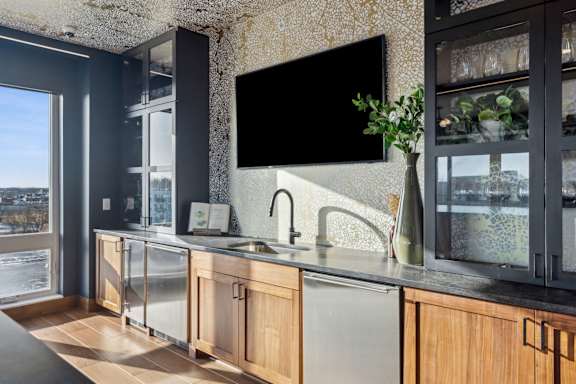 A modern kitchen with a large window overlooking the city.