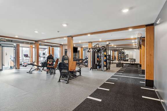 A gym with a variety of equipment including treadmills, weights, and exercise machines.