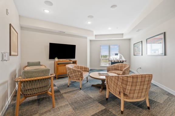 a living room with wicker chairs and a tv