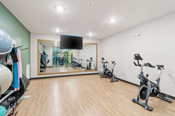 A room with a mirror and exercise equipment.