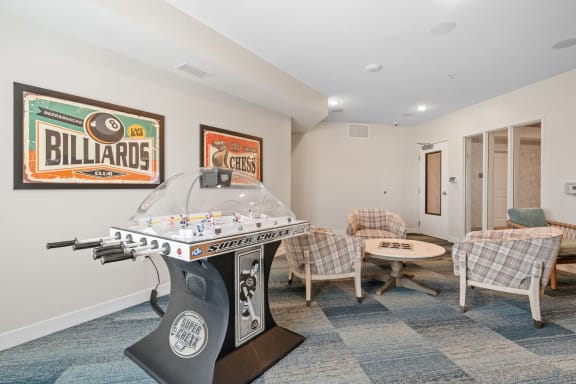 a game room with a foosball table and chairs