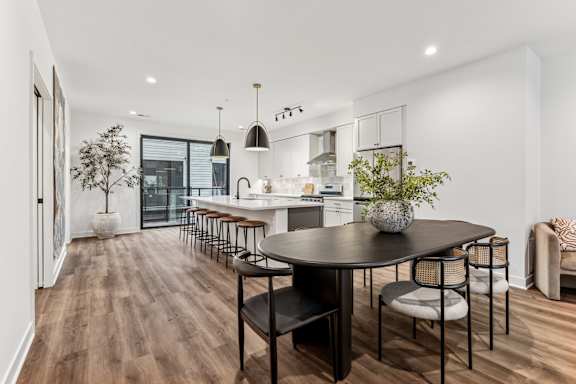 A modern dining room with a large table and chairs.