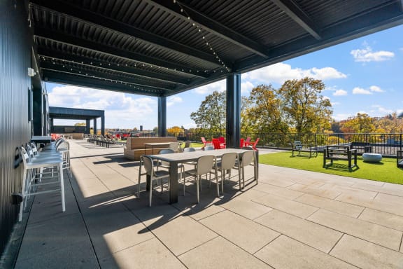 a patio with tables and chairs under a roof