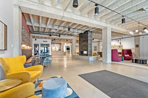 A large open space with a yellow chair and a blue table.