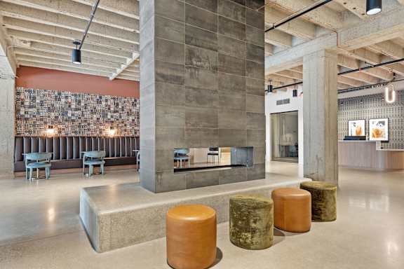 A room with a concrete column and a stone bench.