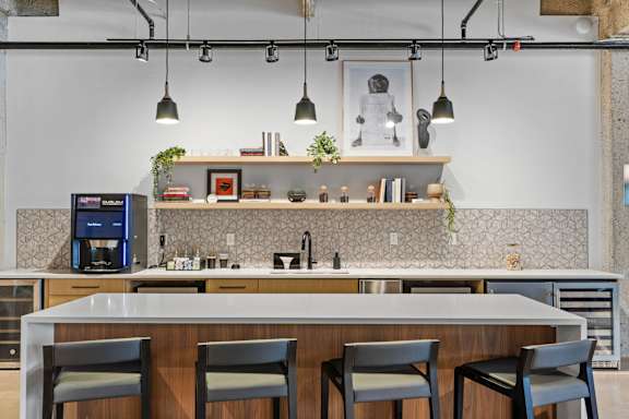 A modern kitchen with a bar area and four chairs.