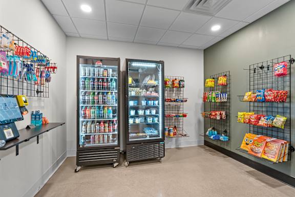 A display of snacks and drinks in a cooler and shelves.