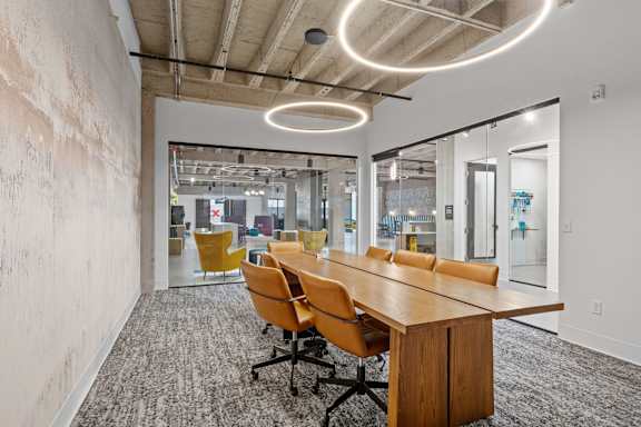 A conference room with a long table and chairs.