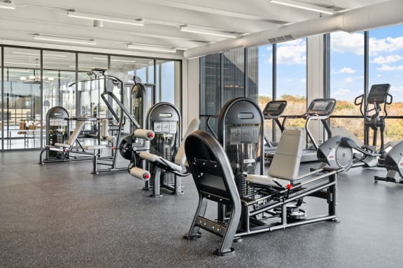a gym with cardio equipment and windows in a building