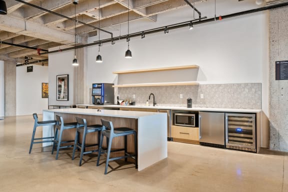 a kitchen with an island and bar stools in a room with exposed ceilings