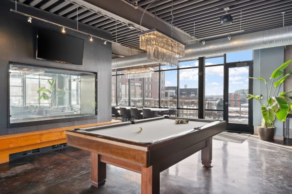 a pool table in a room with a view of a city