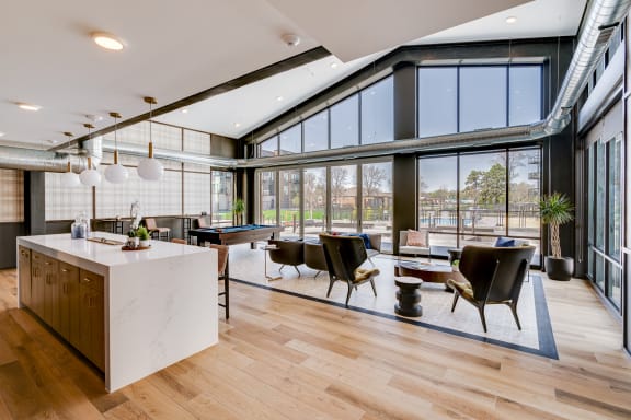 a large open living room with a pool table and a kitchen