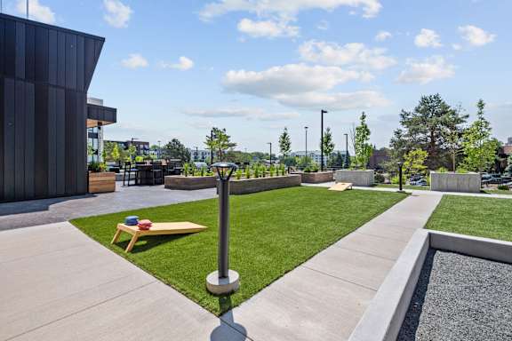 A modern outdoor area with a bench, a pole, and a gravel bed.