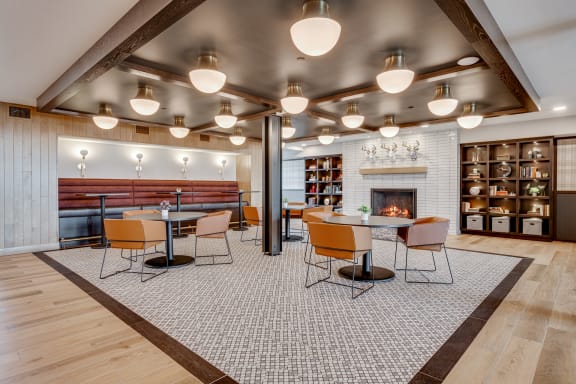 a dining area with tables and chairs and a fireplace