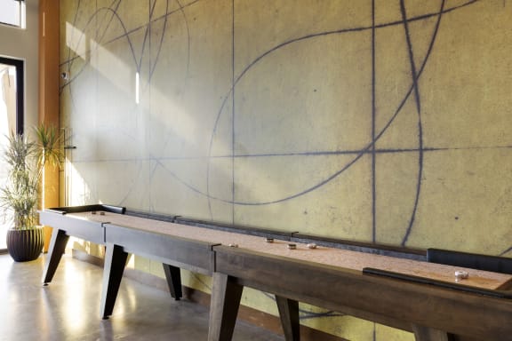 a pool table in the lobby of a building with lines on the wall
