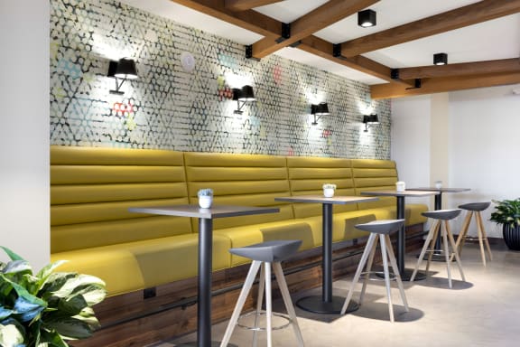 a restaurant with yellow booths and tables with stools