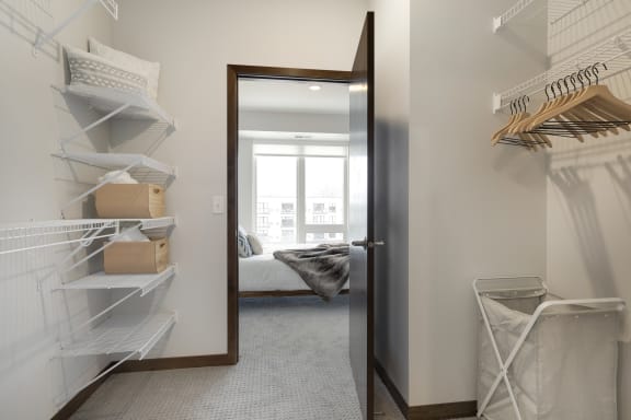 a walk in closet with a mirror and a door to a bedroom
