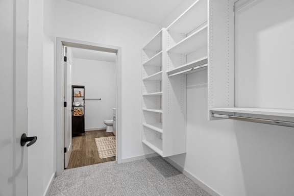 A white hallway with a doorway leading to a bathroom.