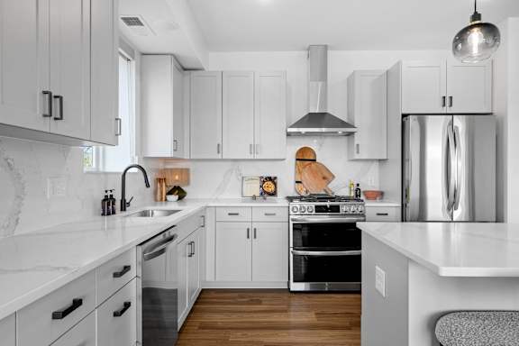 A modern kitchen with white cabinets and stainless steel appliances.