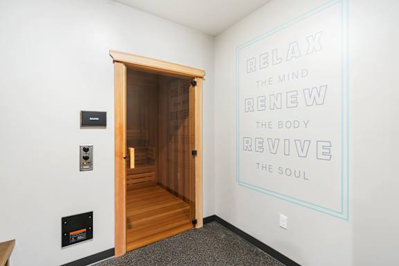 A room with a quote on the wall and a wooden door.