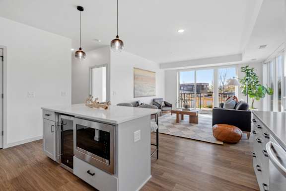 A modern kitchen with a large island and stainless steel appliances.