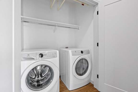 Two white front loading washing machines in a laundry room.
