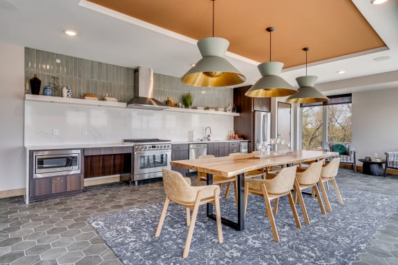 a kitchen with a long wooden table and chairs