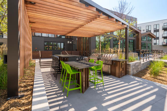 a covered patio with tables and chairs and a grill