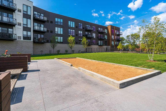 a grassy area with a sod in front of an apartment building