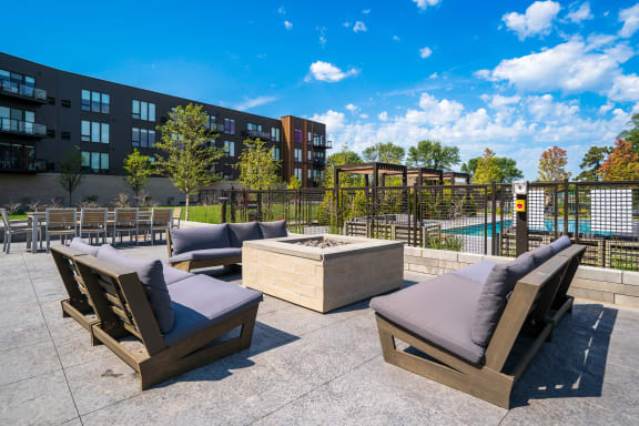an outdoor patio with lounge furniture and a firepit