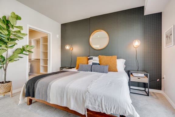 a bedroom with a large bed and a potted plant