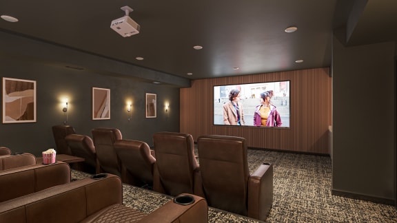 a screening room with brown leather chairs and a large screen