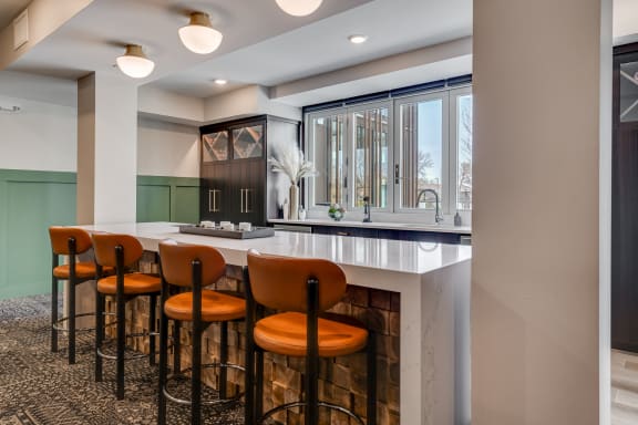 a bar area with stools and a fireplace