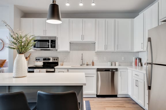 a kitchen with white cabinets and stainless steel appliances