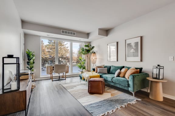a living room with a green couch and a large window