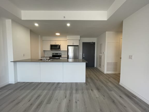 Bayfield Tower Apartments 1 bedroom 1 bathroom variation C kitchen with large breakfast bar, stainless steel appliances and white cabinets