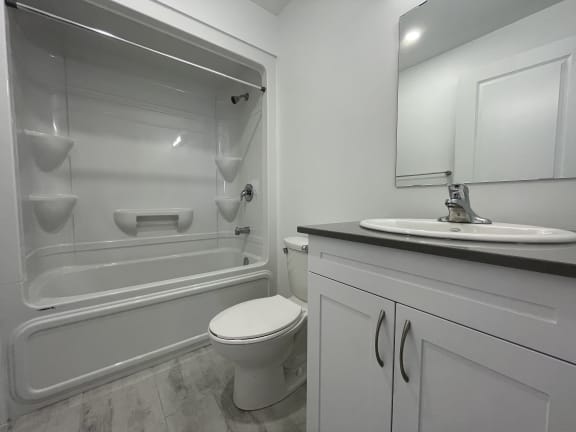 Bayfield Tower Apartments 3 bedroom 2 bathroom variation A primary bathroom with vanity, toilet and tub with a shower