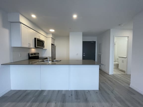 Bayfield Tower Apartments 3 bedroom 2 bathroom variation A kitchen with white cabinets, quartz countertops and stainless steel appliances