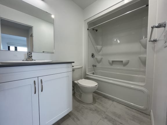Bayfield Tower Apartments 2 bedroom 2 bathroom variation D ensuite bathroom with vanity, large mirror, toilet and tub with a shower