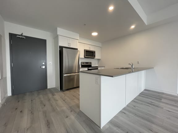 Bayfield Tower 2 bedroom 2 bathroom variation E kitchen with white cabinets, quartz countertops and stainless steel kitchen appliances