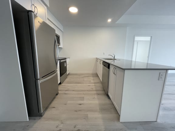 Bayfield Tower 2 bedroom 2 bathroom variation E kitchen with stainless steel fridge, stove, over-the-range microwave and dishwasher