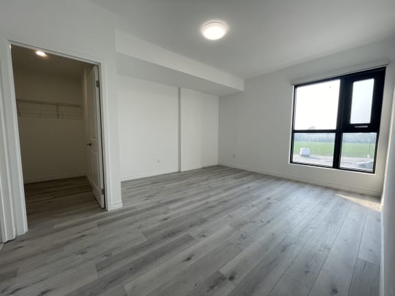 Bayfield Tower 2 bedroom 2 bathroom variation E primary bedroom with large window and a walk-in closet