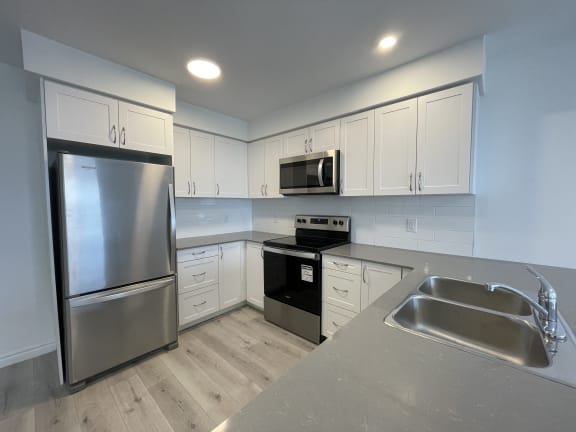 Bayfield Tower Apartments 3 bedroom 2 bathroom variation B kitchen with stainless steel fridge, stove and over-the-range microwave