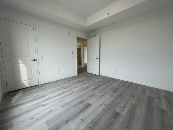 Bayfield Tower Apartments 3 bedroom 2 bathroom variation B third bedroom looking towards doorway with a closet door on the left side of the wall