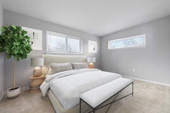 A bedroom with a large bed and a potted plant.