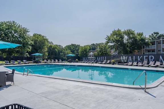 A large outdoor swimming pool with lounge chairs and umbrellas.