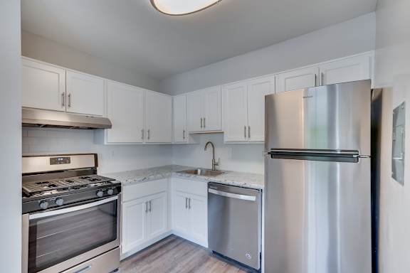 A modern kitchen with stainless steel appliances and white cabinets.