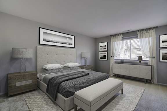 A bedroom with a large bed and a window with curtains.