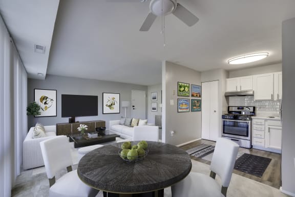 A modern living room with a black table and white chairs.