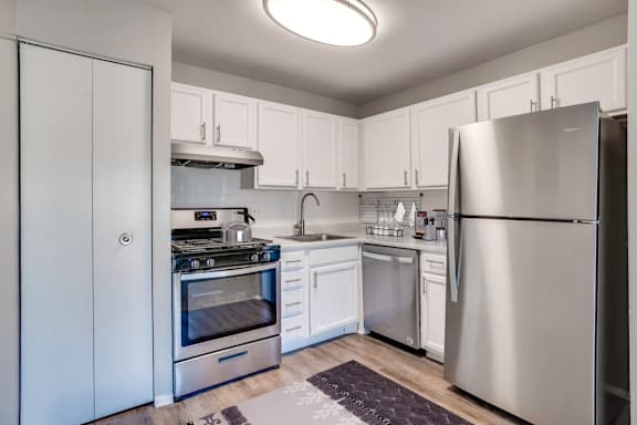 A modern kitchen with stainless steel appliances and white cabinets.